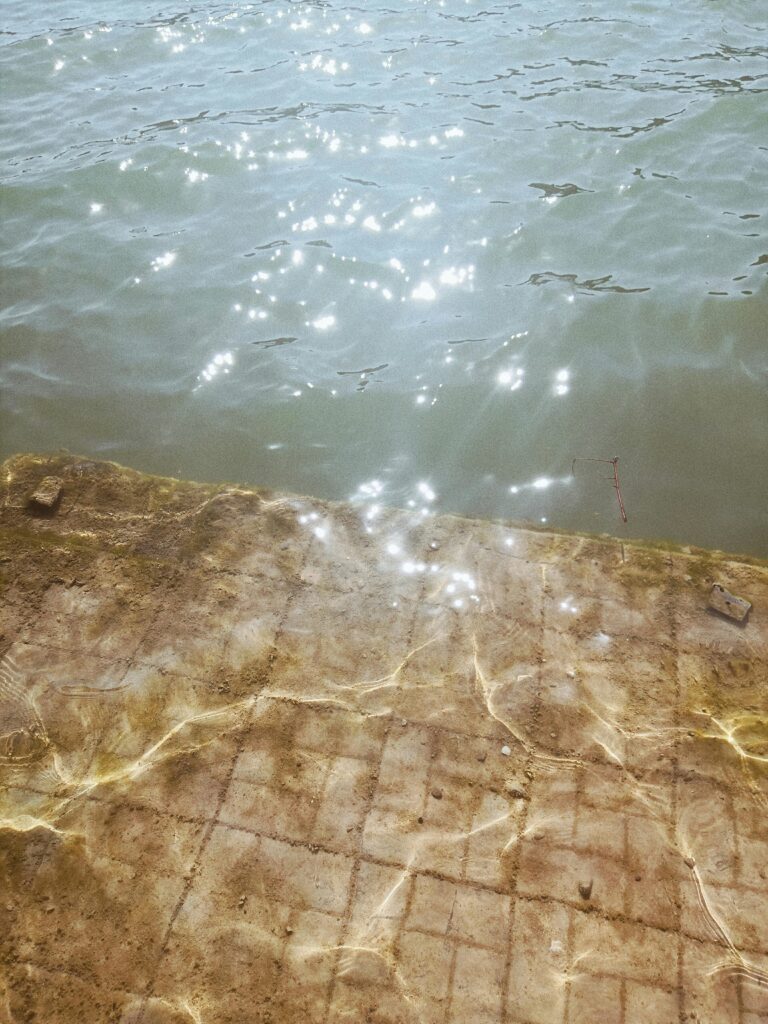 pexels-photo-9049059-9049059 Sunlight sparkles on water beside a tile surface, creating a serene outdoor scene.